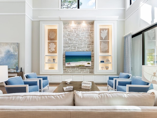 living room featuring a towering ceiling and light hardwood / wood-style flooring