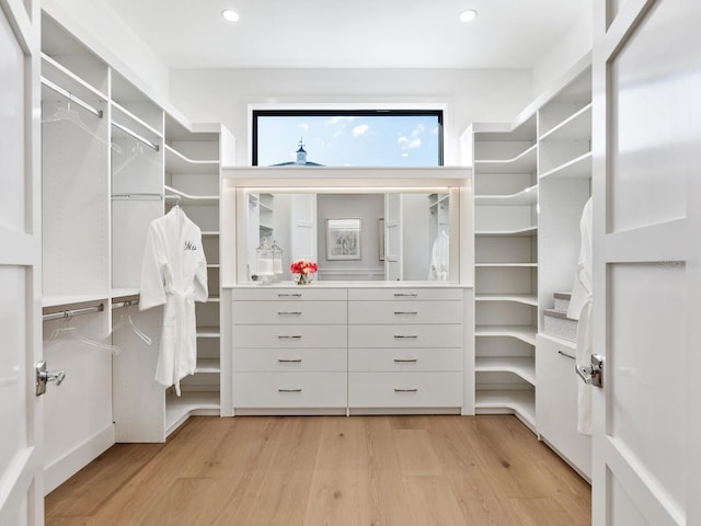 walk in closet with light hardwood / wood-style floors