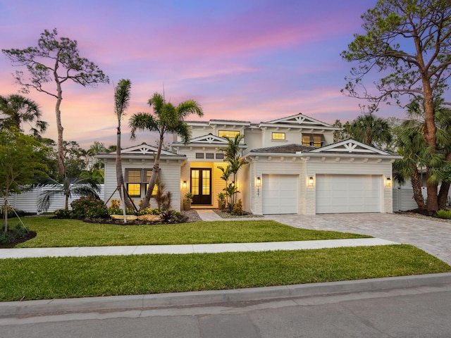 view of front of property featuring a garage and a lawn