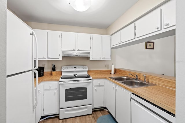 kitchen with white cabinetry, sink, white appliances, and hardwood / wood-style floors