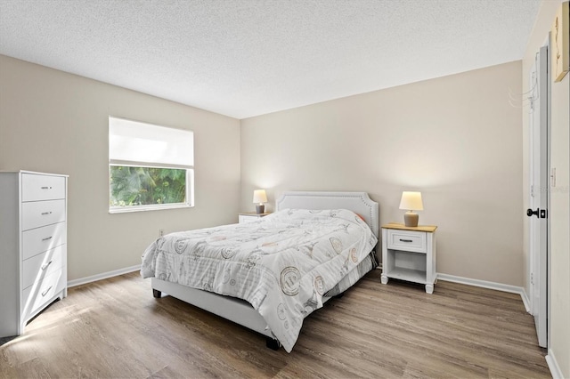 bedroom with hardwood / wood-style floors and a textured ceiling