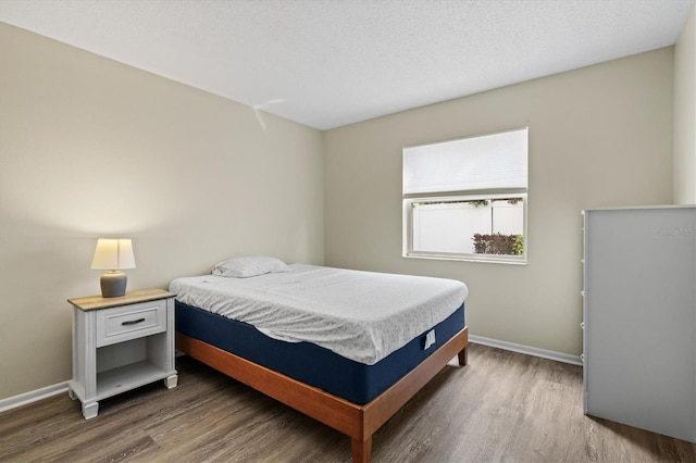 bedroom featuring dark wood-type flooring and a textured ceiling