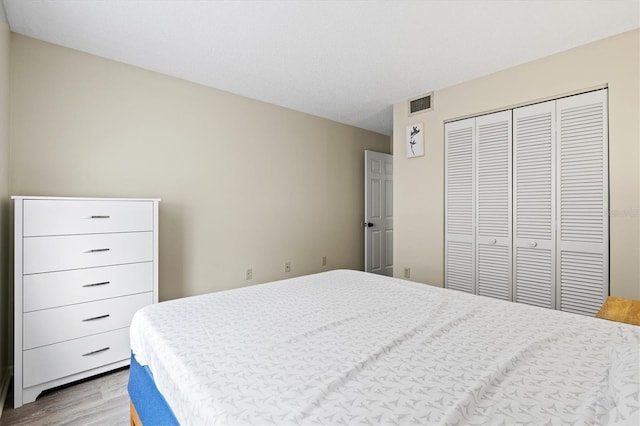 bedroom with light wood-type flooring and a closet