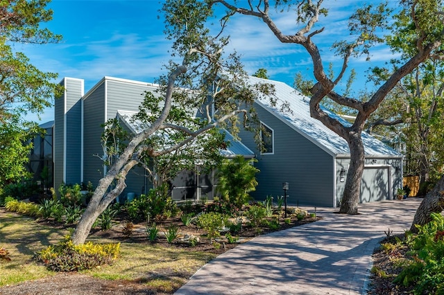 view of home's exterior with a garage and decorative driveway