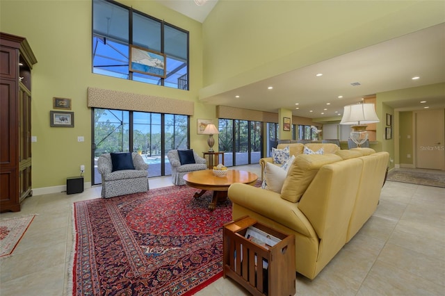 living room with light tile patterned flooring and a towering ceiling