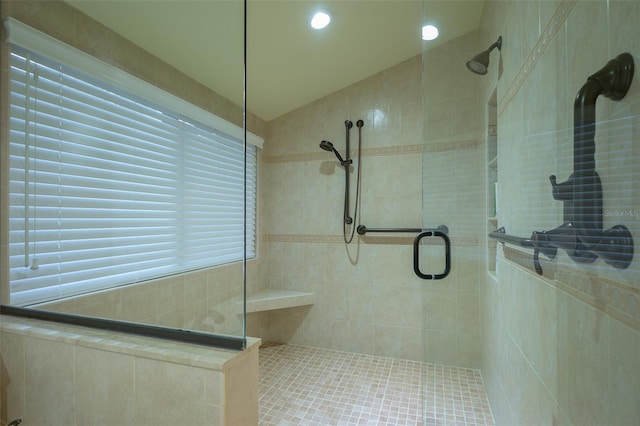 bathroom featuring a shower with door and lofted ceiling