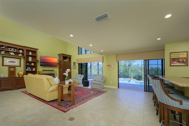 living area featuring recessed lighting, a fireplace, a sunroom, baseboards, and visible vents