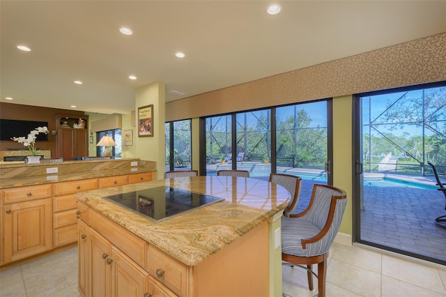 kitchen featuring light stone counters, recessed lighting, black electric stovetop, and light tile patterned floors