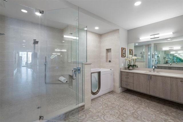 bathroom with a shower with door, vanity, and tile patterned floors