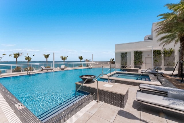 view of swimming pool with a water view, a hot tub, and a patio