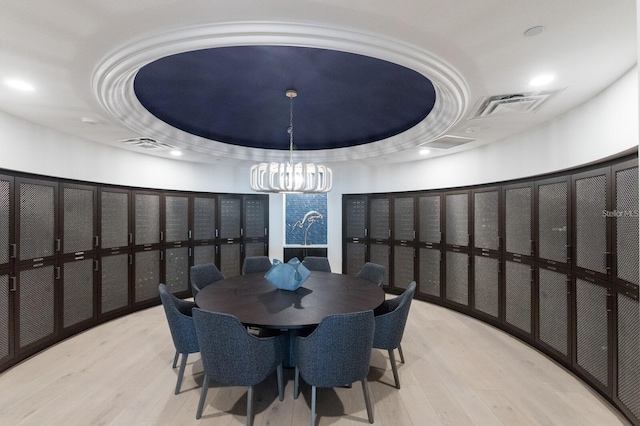 dining room with a tray ceiling and light hardwood / wood-style floors