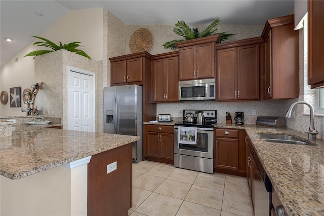 kitchen with lofted ceiling, sink, light tile patterned floors, appliances with stainless steel finishes, and light stone countertops