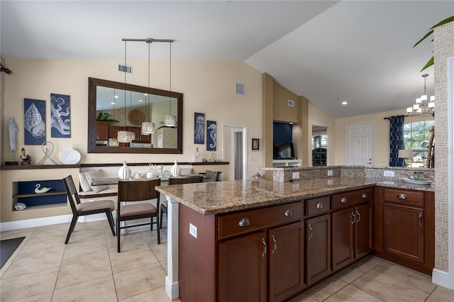 kitchen featuring vaulted ceiling, light tile patterned floors, kitchen peninsula, pendant lighting, and dark stone counters