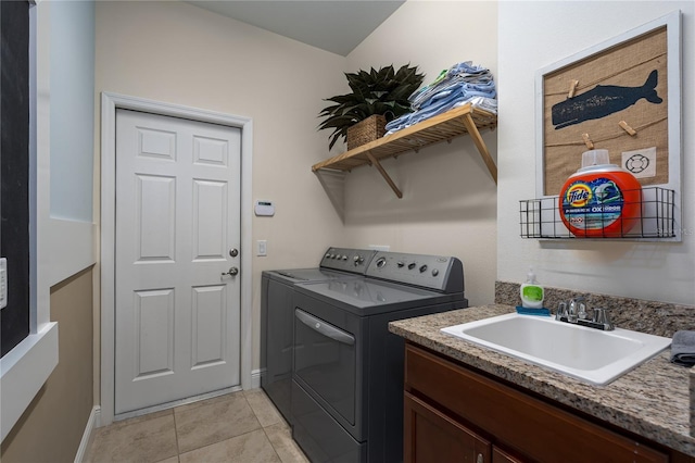 washroom featuring sink, light tile patterned floors, cabinets, and washing machine and clothes dryer