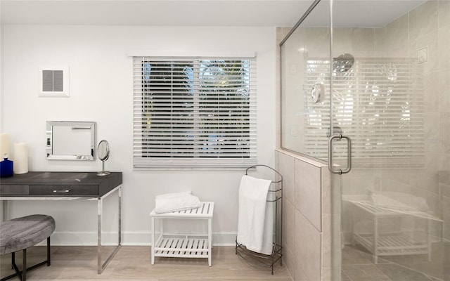 bathroom with wood-type flooring and an enclosed shower