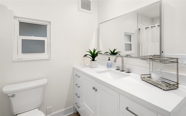 bathroom featuring vanity, a shower with shower curtain, and toilet