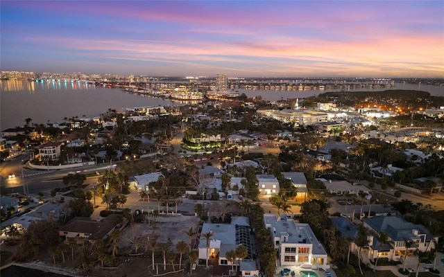 aerial view at dusk featuring a water view