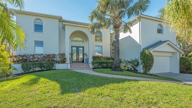 mediterranean / spanish-style home featuring french doors, a garage, and a front yard