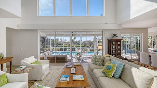 living room with plenty of natural light, a towering ceiling, and hardwood / wood-style floors