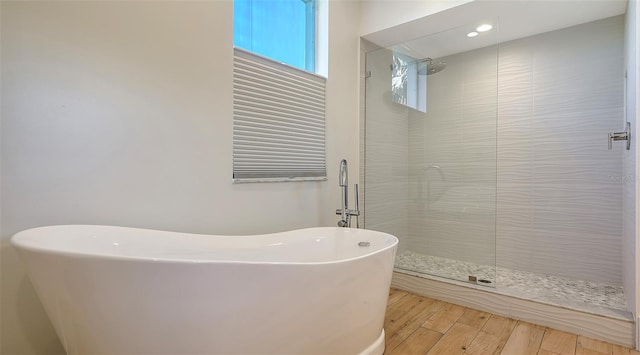 bathroom with wood-type flooring and plus walk in shower