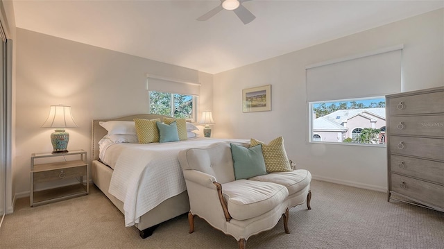 carpeted bedroom with multiple windows and ceiling fan