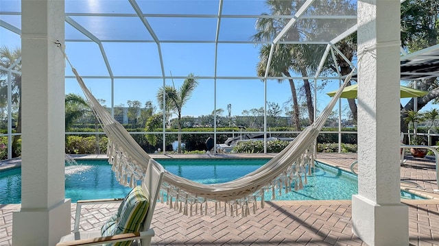 view of pool featuring pool water feature, a water slide, and glass enclosure