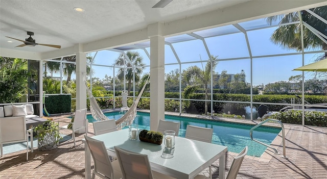 sunroom / solarium featuring ceiling fan, plenty of natural light, and a swimming pool