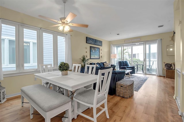 dining space with ceiling fan and light wood-type flooring