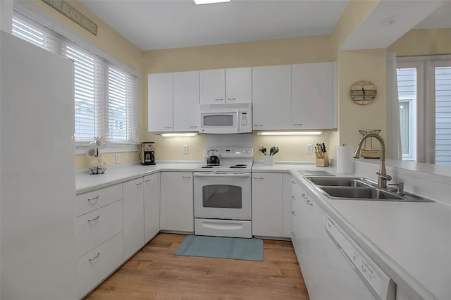 kitchen with white appliances, light hardwood / wood-style floors, sink, and white cabinets