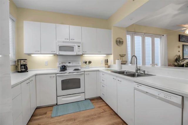 kitchen featuring sink, white appliances, light hardwood / wood-style floors, and white cabinets