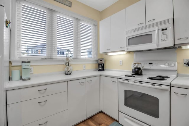 kitchen with white cabinetry, white appliances, and light hardwood / wood-style flooring