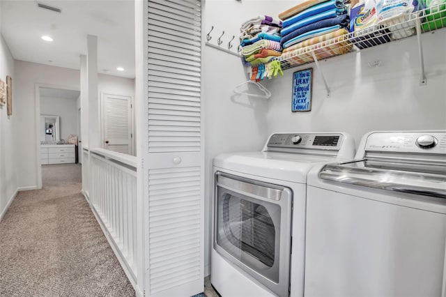 laundry area with washer and dryer and light carpet