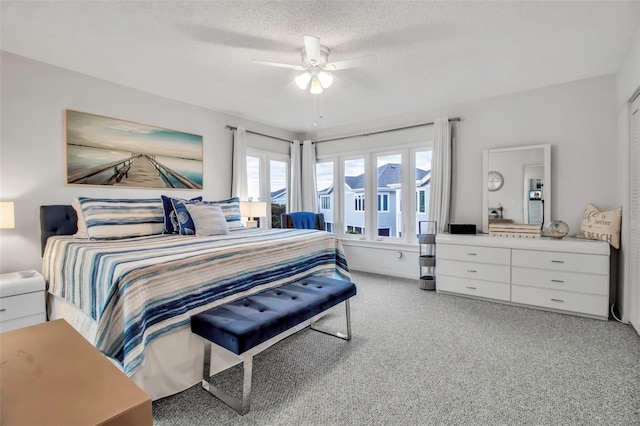 bedroom featuring light carpet, ceiling fan, and a textured ceiling