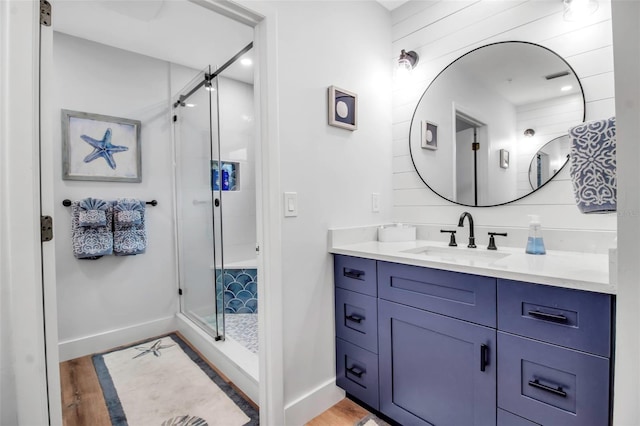 bathroom with vanity, hardwood / wood-style floors, and a shower with shower door