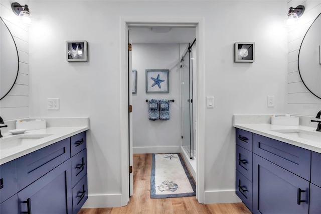 bathroom with vanity, an enclosed shower, and wood-type flooring