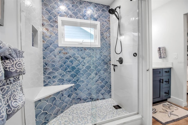 bathroom with vanity and tiled shower