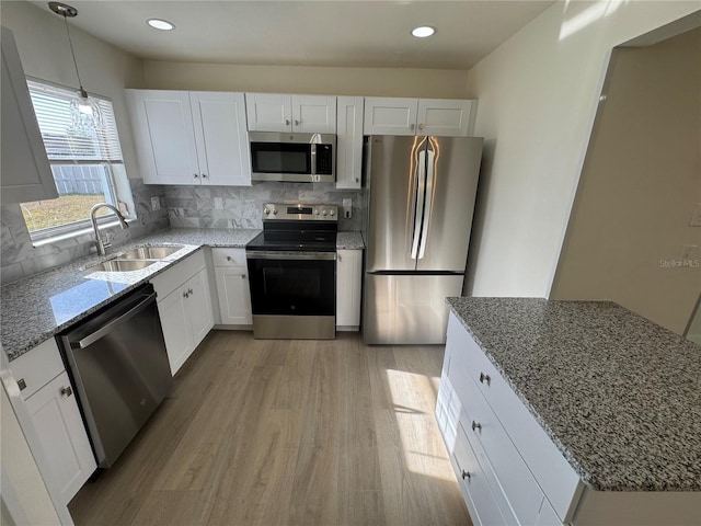 kitchen with sink, appliances with stainless steel finishes, backsplash, white cabinets, and stone countertops