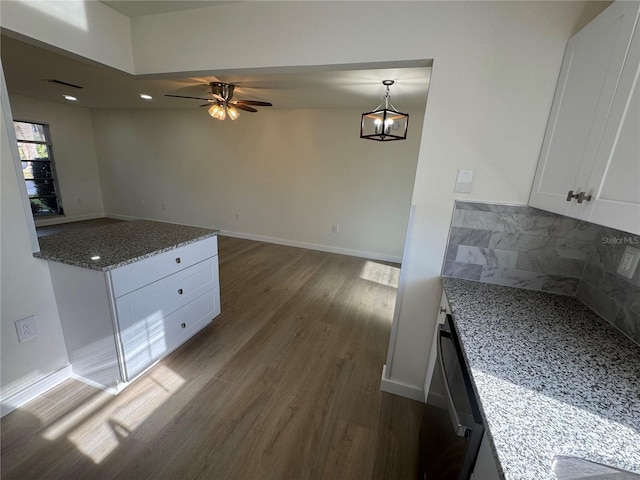 kitchen featuring stone counters, white cabinetry, black dishwasher, tasteful backsplash, and dark hardwood / wood-style flooring