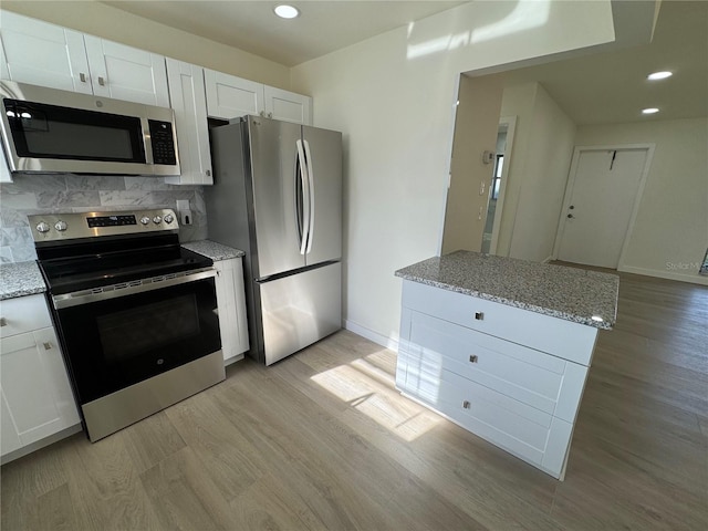 kitchen featuring light stone counters, white cabinets, and appliances with stainless steel finishes