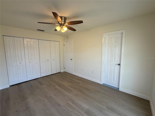 unfurnished bedroom with hardwood / wood-style flooring, ceiling fan, and a closet