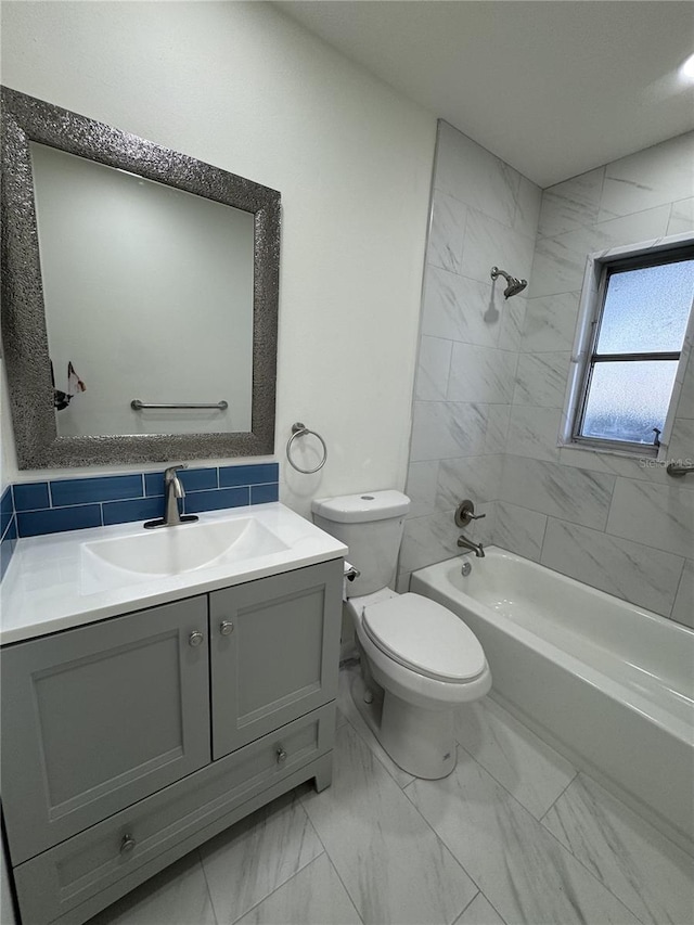 full bathroom with vanity, tiled shower / bath combo, and toilet