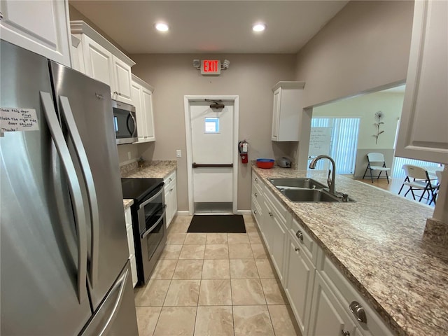 kitchen with sink, light tile patterned floors, stainless steel appliances, and white cabinets