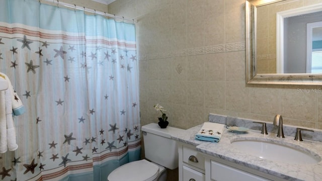 bathroom featuring tile walls, vanity, toilet, and a shower with shower curtain