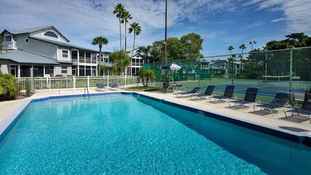 view of swimming pool with tennis court