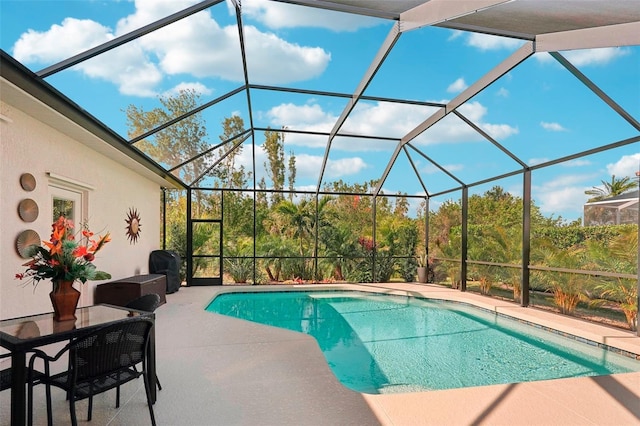 outdoor pool with glass enclosure and a patio