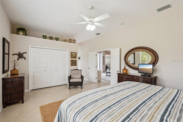 bedroom with lofted ceiling, light tile patterned floors, a closet, and ceiling fan