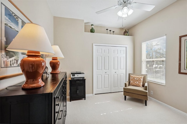 living area featuring light carpet and ceiling fan