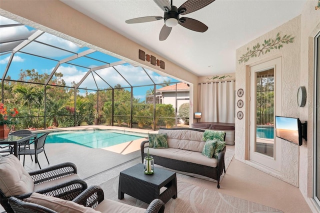 view of pool with an outdoor living space, a patio area, ceiling fan, and glass enclosure