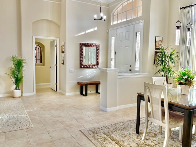 entryway with a chandelier, light tile patterned floors, a high ceiling, and a wealth of natural light