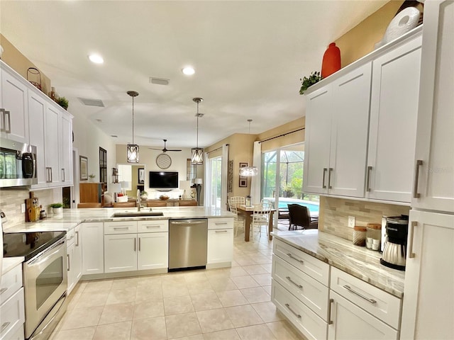 kitchen featuring appliances with stainless steel finishes, white cabinetry, sink, backsplash, and light tile patterned floors